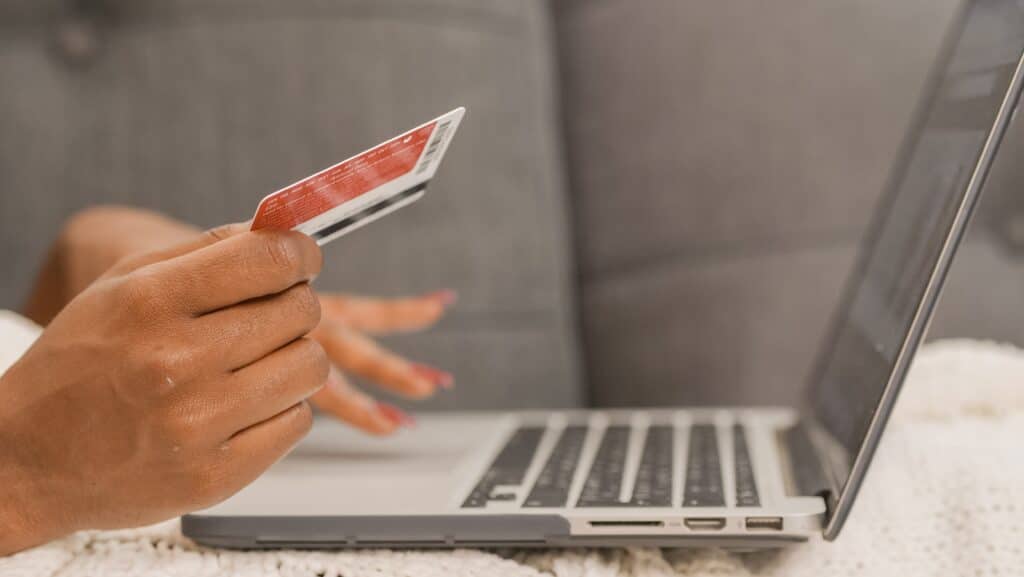 consumidora segura cartão em mão apara colcoar dados em notebook, no marketplace