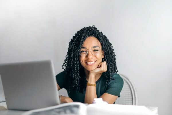 menina sorri enquanto estuda com EdTech no notebook